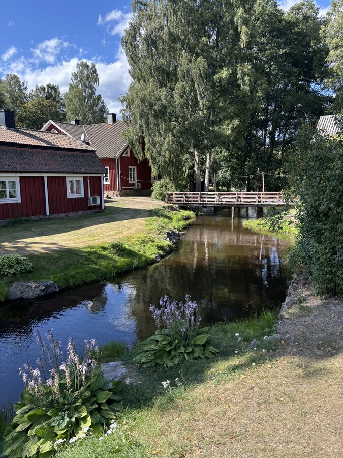 Roter Hof am Kanal mit kleiner Holzbrücke in Korrö